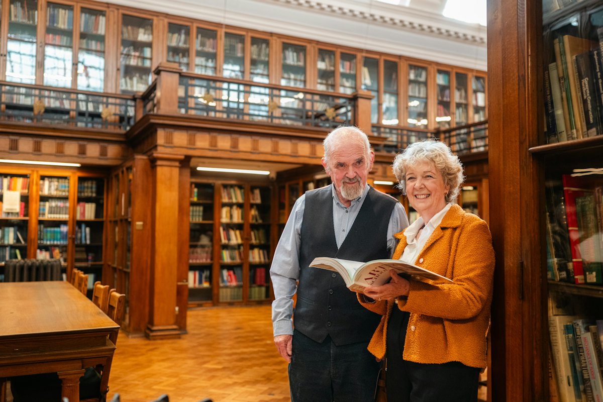 A retired couple reading together in a library